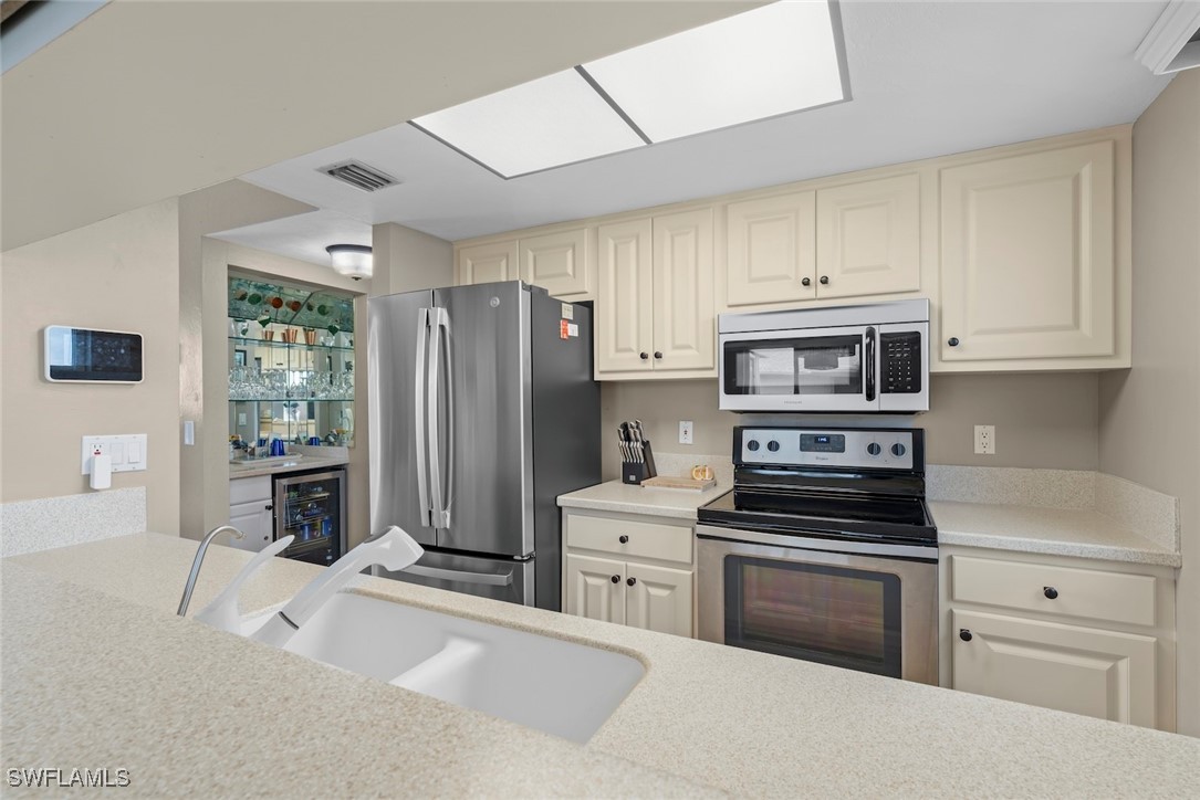 1651 Sand Castle Road Sanibel, FL 33957 - Photo 18 of 50 a kitchen with stainless steel appliances a refrigerator stove and cabinets