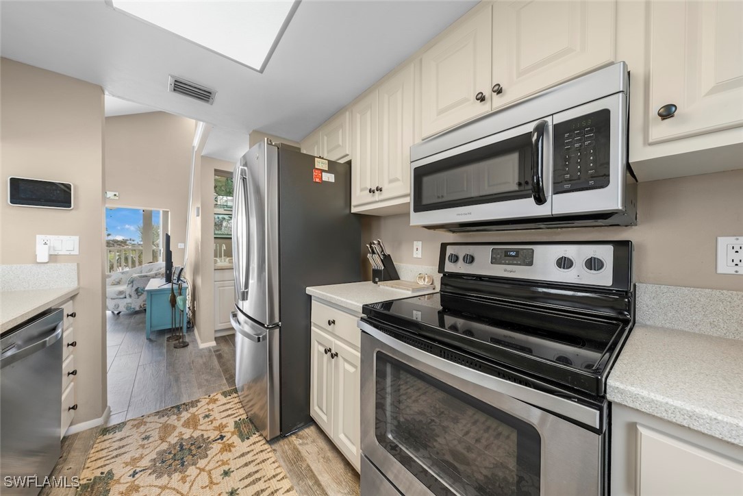 1651 Sand Castle Road Sanibel, FL 33957 - Photo 21 of 50 a kitchen with wooden cabinets and stainless steel appliances