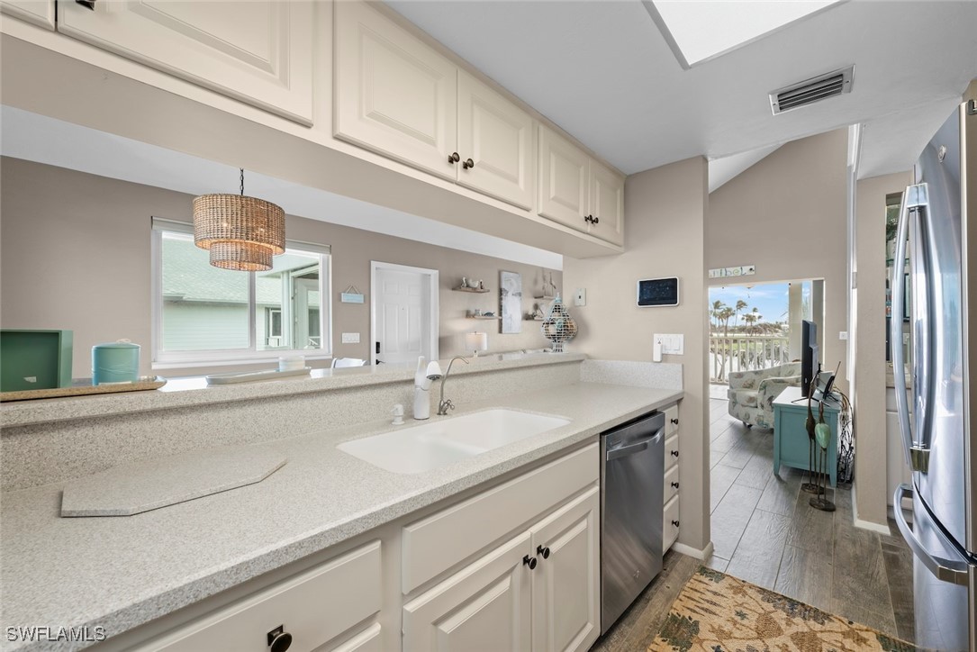 1651 Sand Castle Road Sanibel, FL 33957 - Photo 22 of 50 a kitchen with stainless steel appliances a sink stove and refrigerator