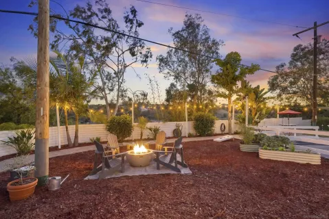 a view of a backyard with table and chairs and a fire pit