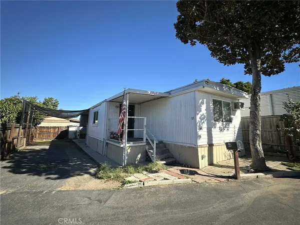 a view of a house with backyard and a tree