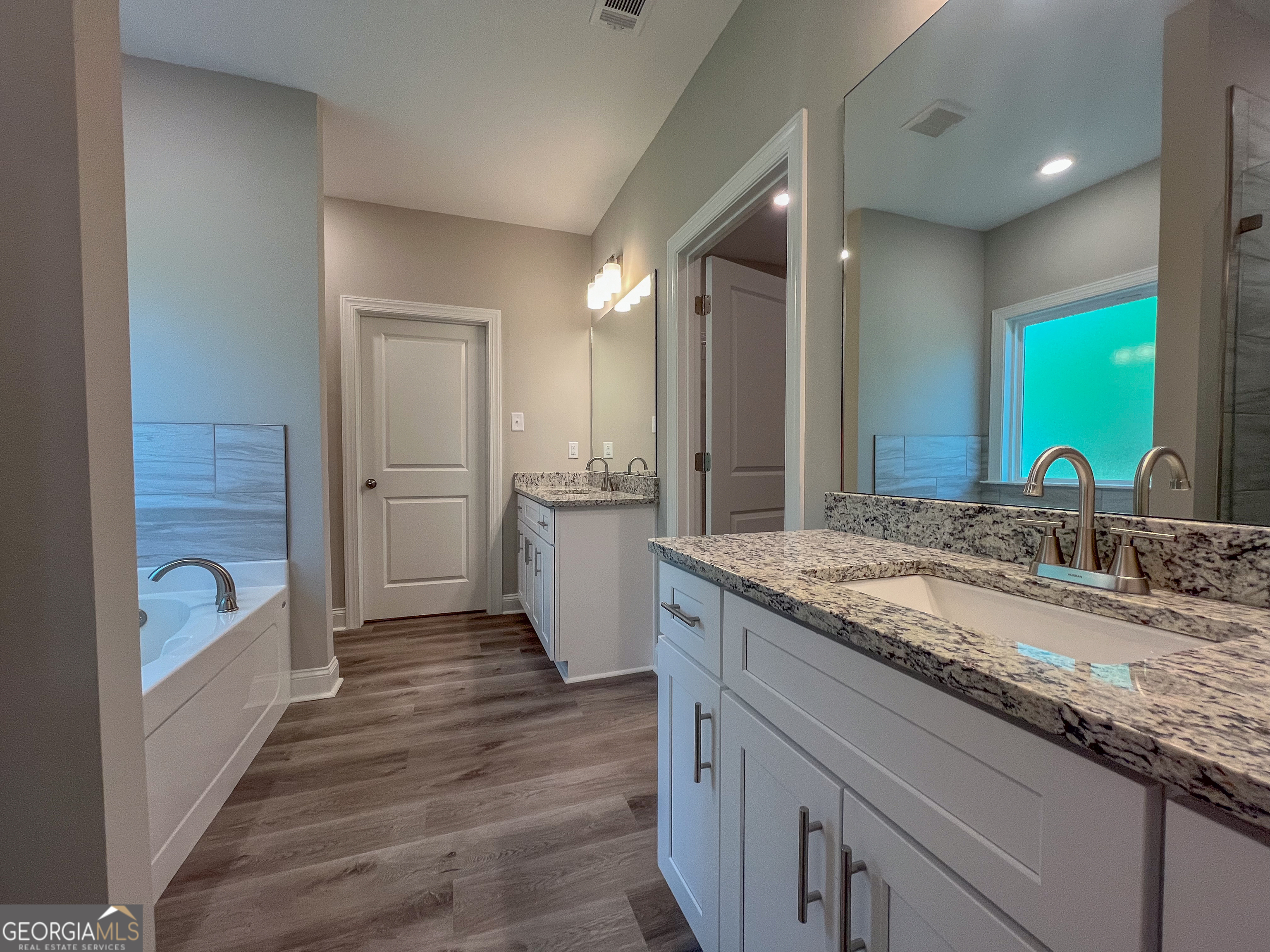 711 Flanders Lane Dublin, GA 31021 - Photo 23 of 49 a bathroom with a granite countertop sink mirror and a bathtub