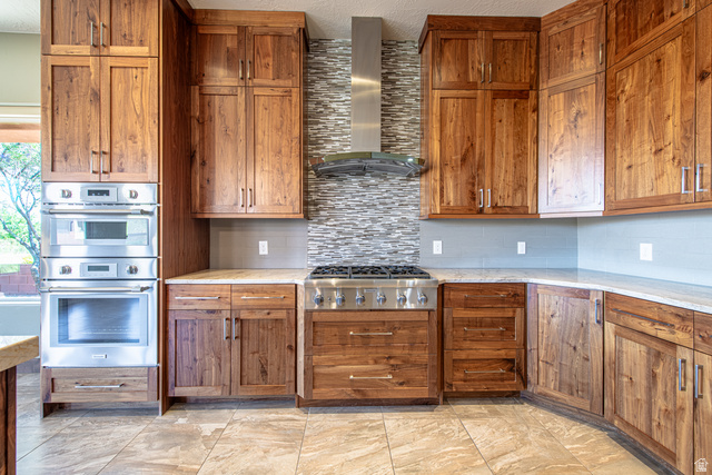 322 340 E Street Ivins, UT 84738 - Photo 14 of 61 Gourmet kitchen with custom wood cabinetry, stainless steel double ovens, a six-burner gas range, and a mosaic tile backsplash
