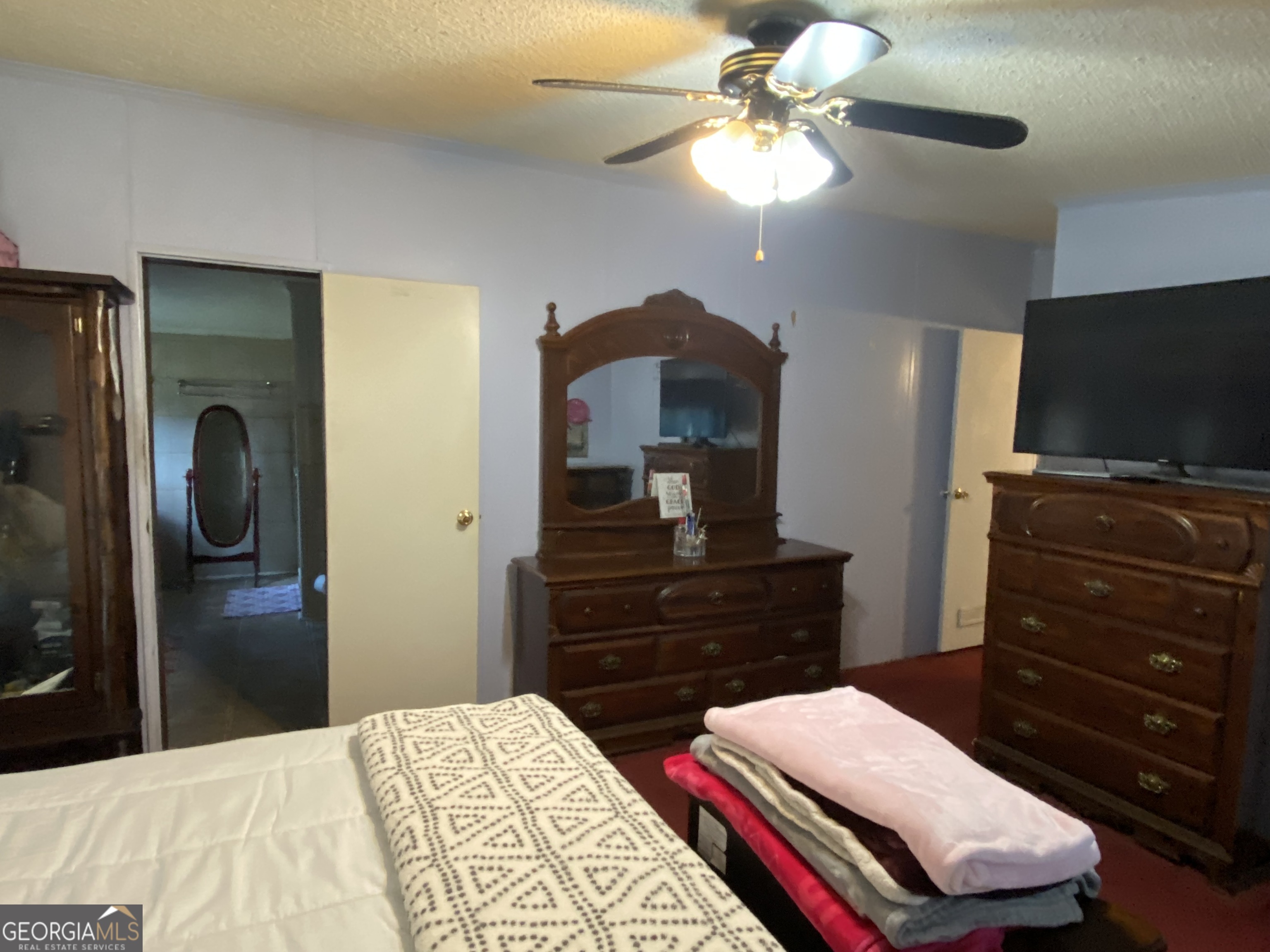 580 Centralia Rachels Road Warthen, GA 31094 - Photo 17 of 40 a bedroom with a bed and a flat tv screen on dresser