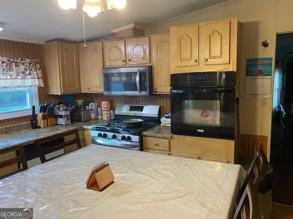 a kitchen with stainless steel appliances granite countertop a stove top oven a sink dishwasher and a microwave