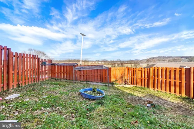 a view of a backyard with swimming pool and wooden fence