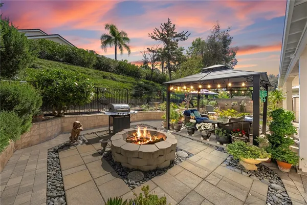 a view of a patio with dining table and chairs with a fire pit