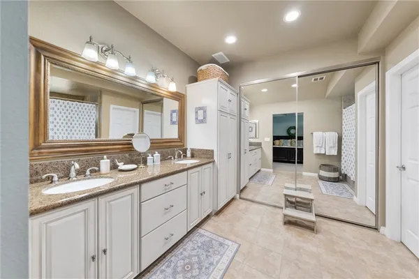 a bathroom with a granite countertop sink two mirror and a