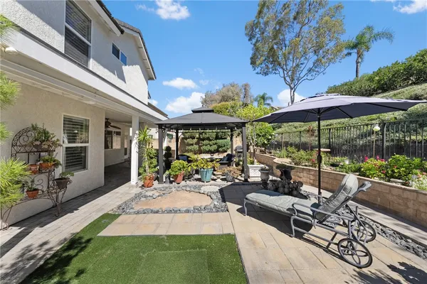 a view of a patio with table and chairs under an umbrella