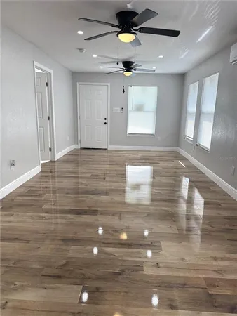a view of an empty room and window and wooden floor