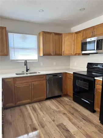 a kitchen with stainless steel appliances granite countertop a sink a stove and cabinets