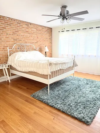 a bathroom with a granite countertop sink a toilet and a window