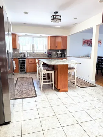 a kitchen with stainless steel appliances kitchen island granite countertop a refrigerator a stove a sink and white cabinets