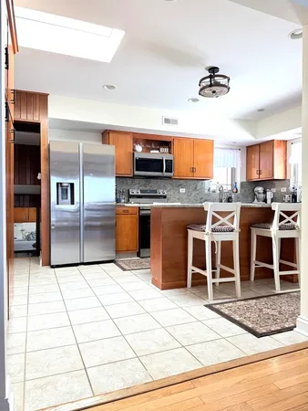 a kitchen with stainless steel appliances kitchen island granite countertop a stove top oven and cabinets