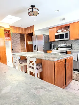 a kitchen with stainless steel appliances granite countertop a stove top oven a sink dishwasher and cabinets with wooden floor