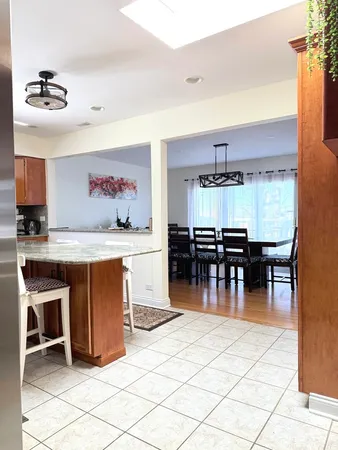 a kitchen with stainless steel appliances kitchen island granite countertop a stove a sink a dining table and chairs