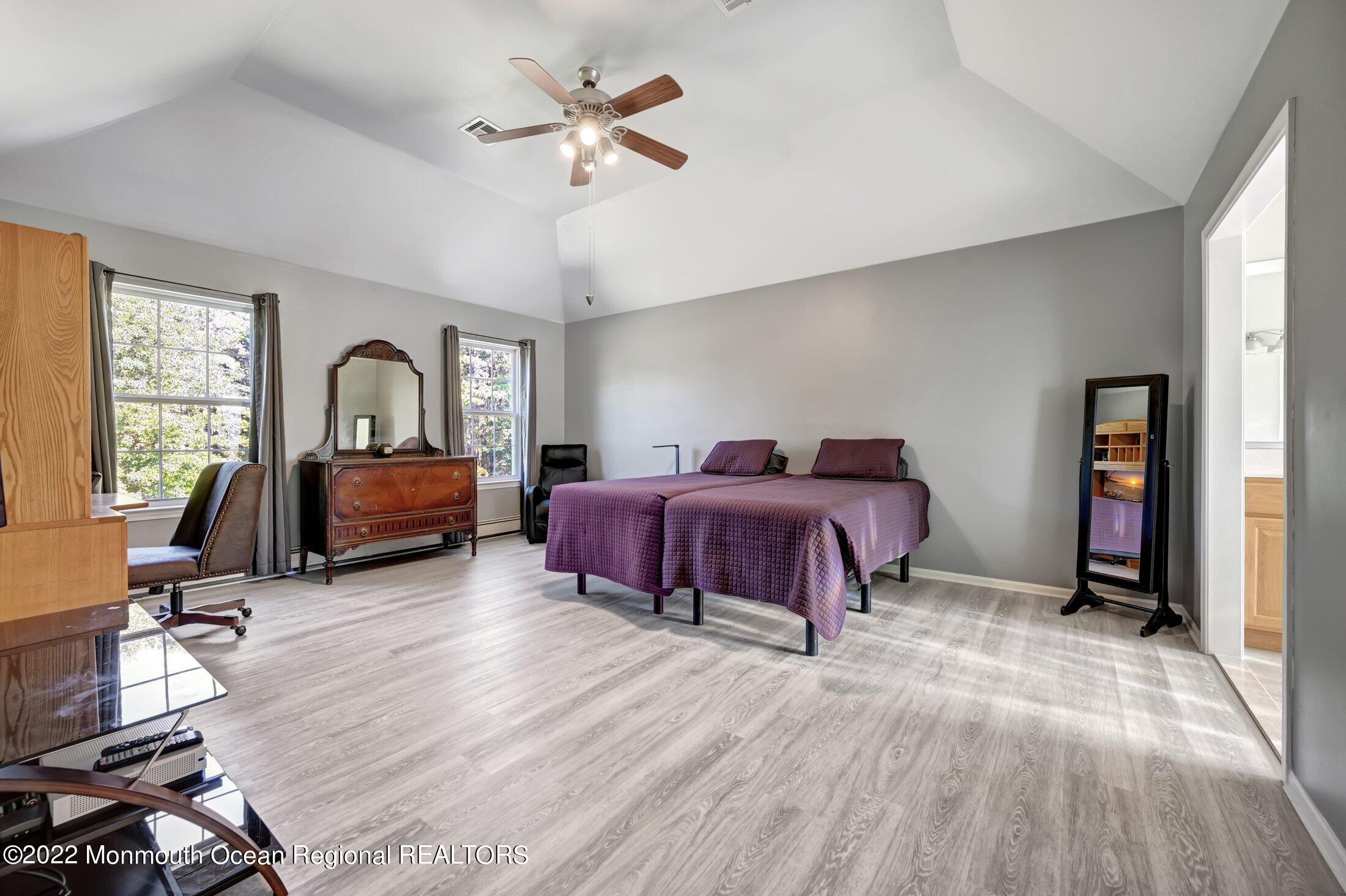 601 Reed Road Jackson, NJ 08527 - Photo 21 of 43 a spacious bedroom with a bed and a chandelier
