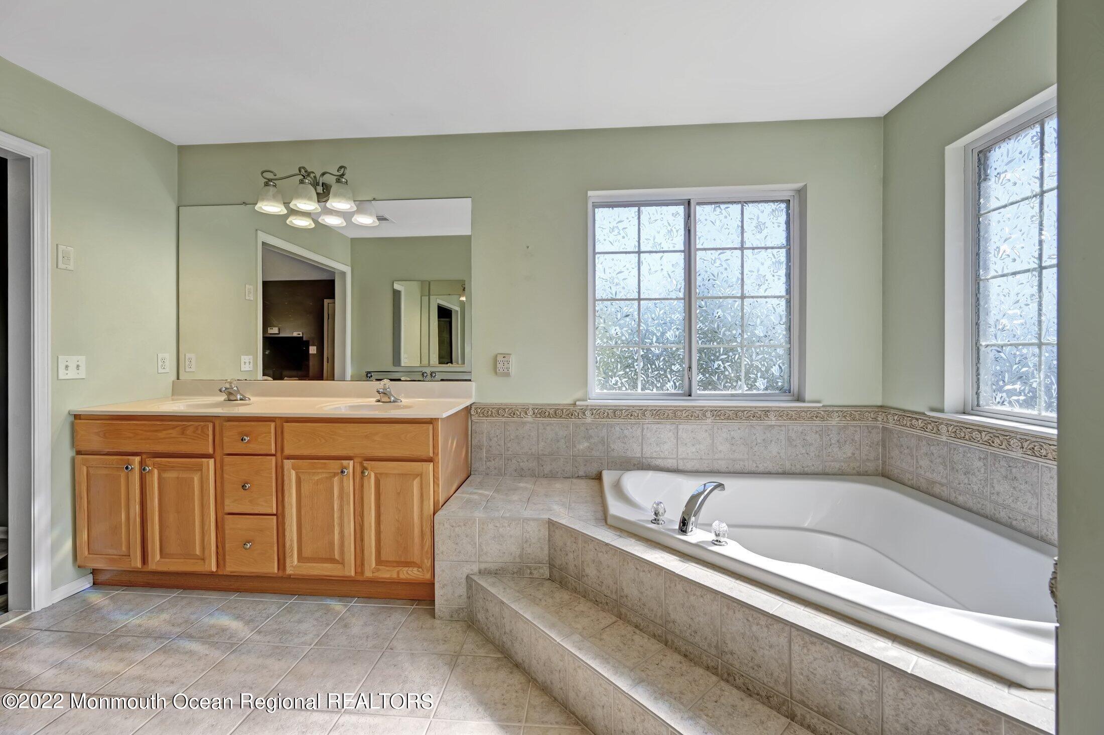 601 Reed Road Jackson, NJ 08527 - Photo 25 of 43 a spacious bathroom with a tub sink and mirror