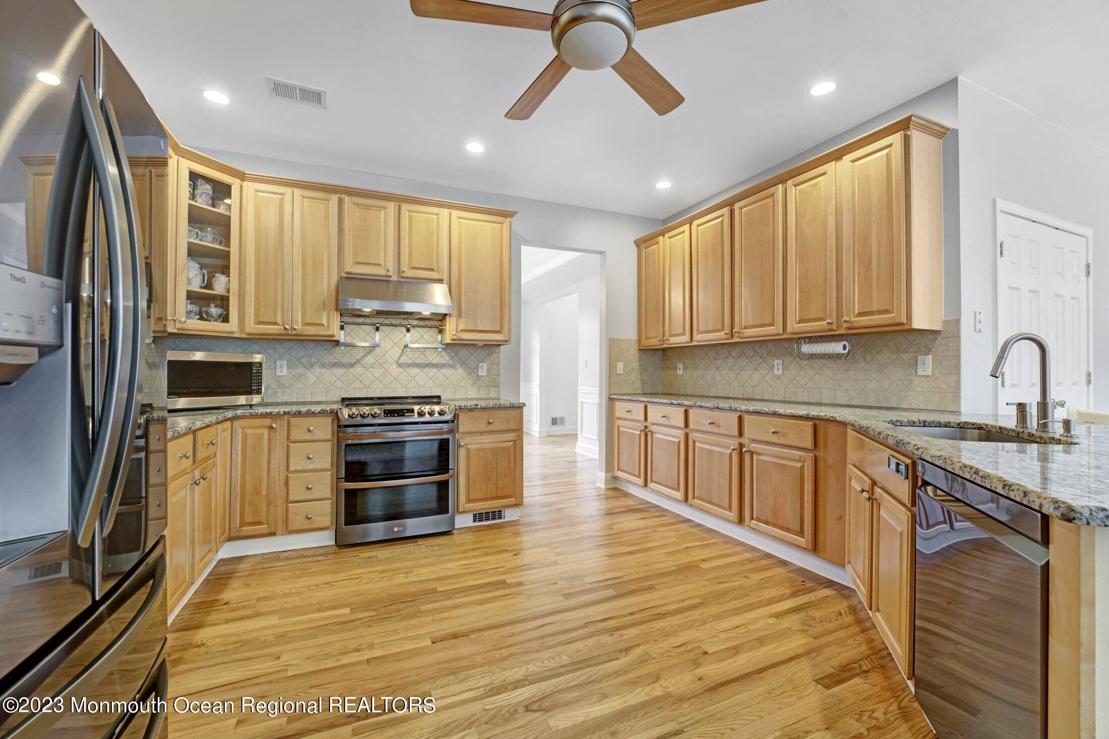 601 Reed Road Jackson, NJ 08527 - Photo 9 of 43 a kitchen with stainless steel appliances kitchen island granite countertop a stove a sink and a refrigerator