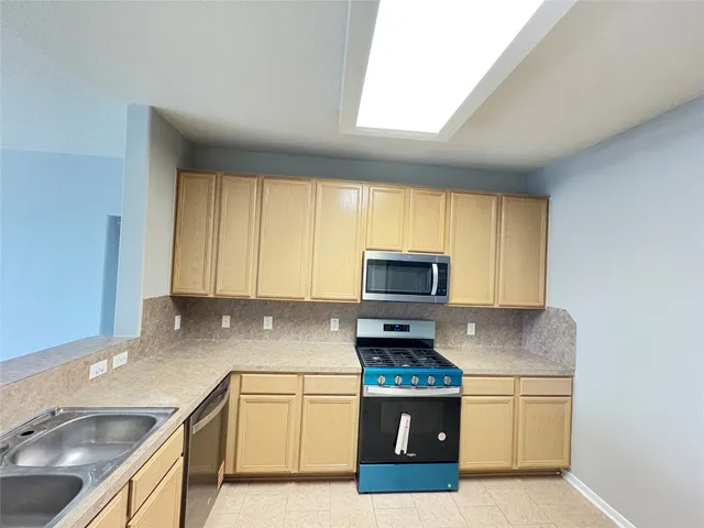 a kitchen with stainless steel appliances granite countertop a sink a stove a microwave a sink and cabinets