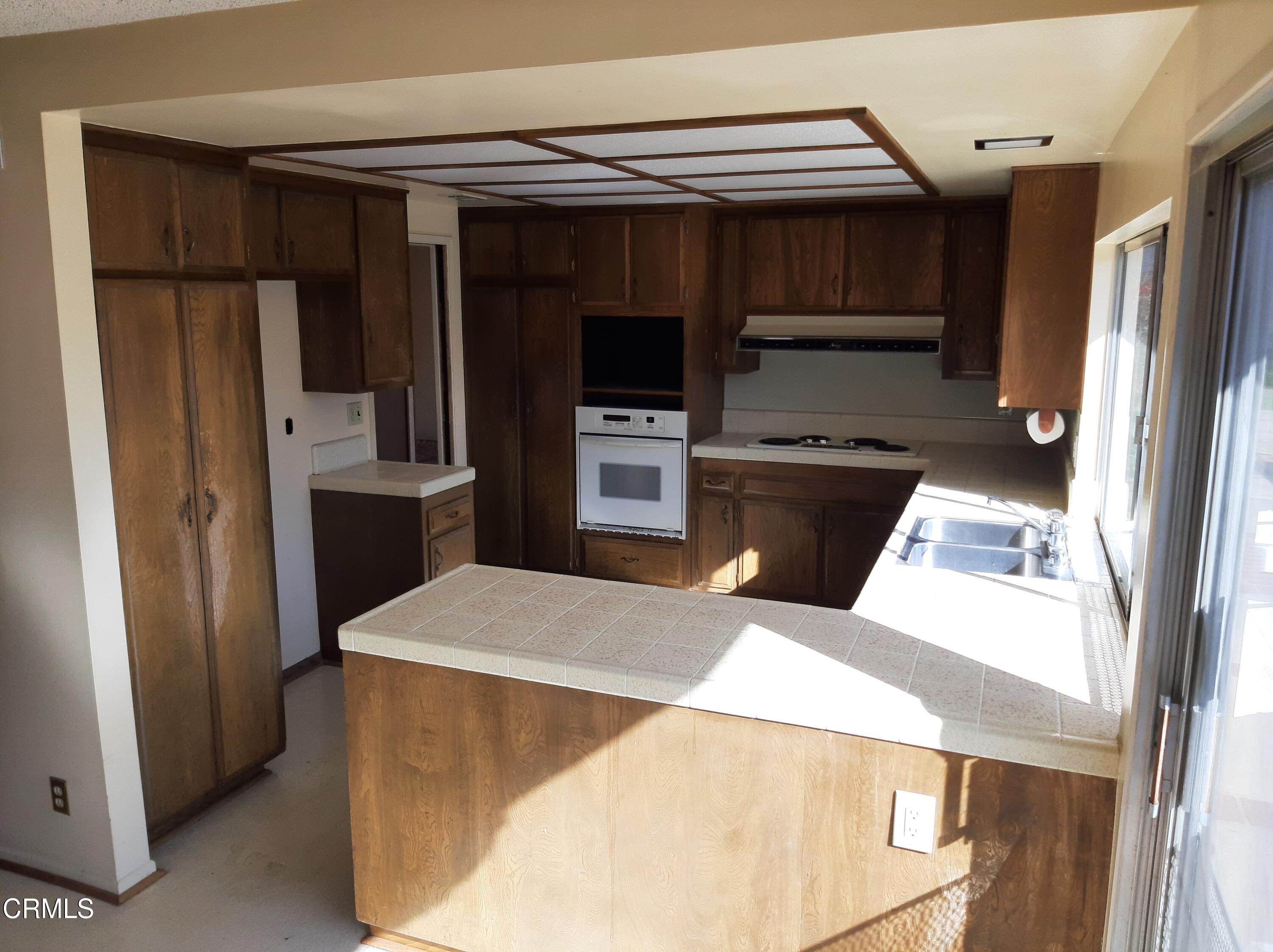 3166 Old Coach Drive Camarillo, CA 93010 - Photo 14 of 55 a kitchen with stainless steel appliances kitchen island a refrigerator sink and stove