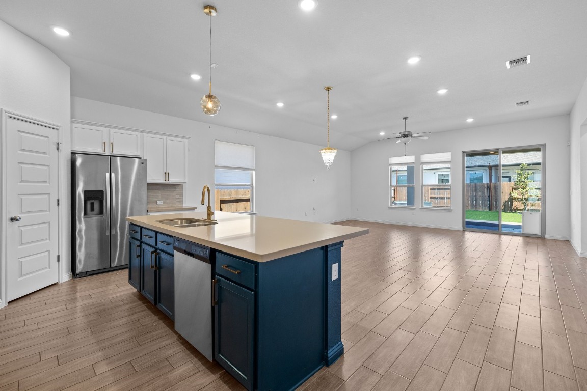 a kitchen with stainless steel appliances granite countertop a kitchen island a stove and a wooden floors