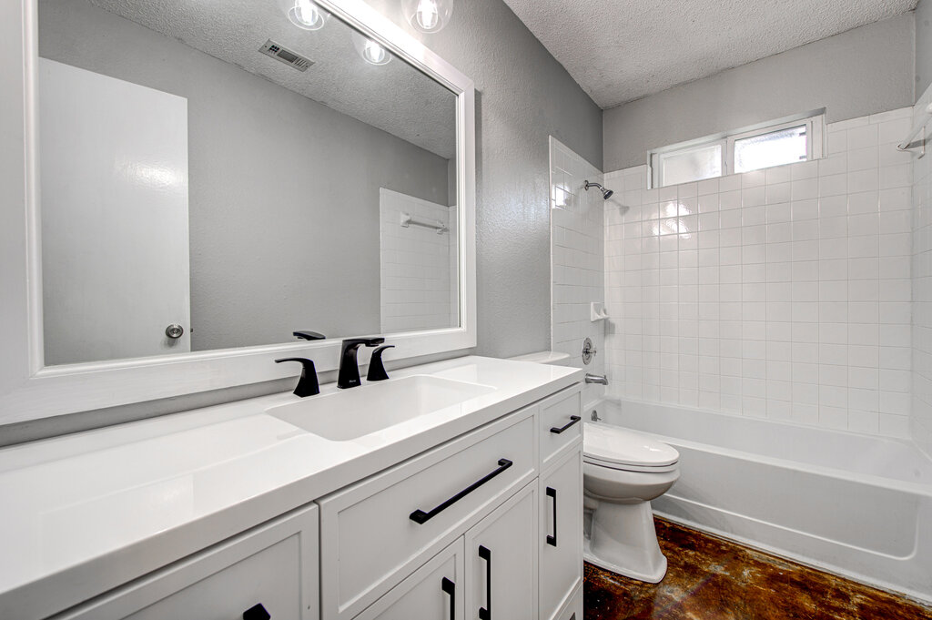 12925 Covington Trail Austin, TX 78727 - Photo 12 of 28 Bathroom featuring shower combination, a textured ceiling, vanity, and a textured wall
