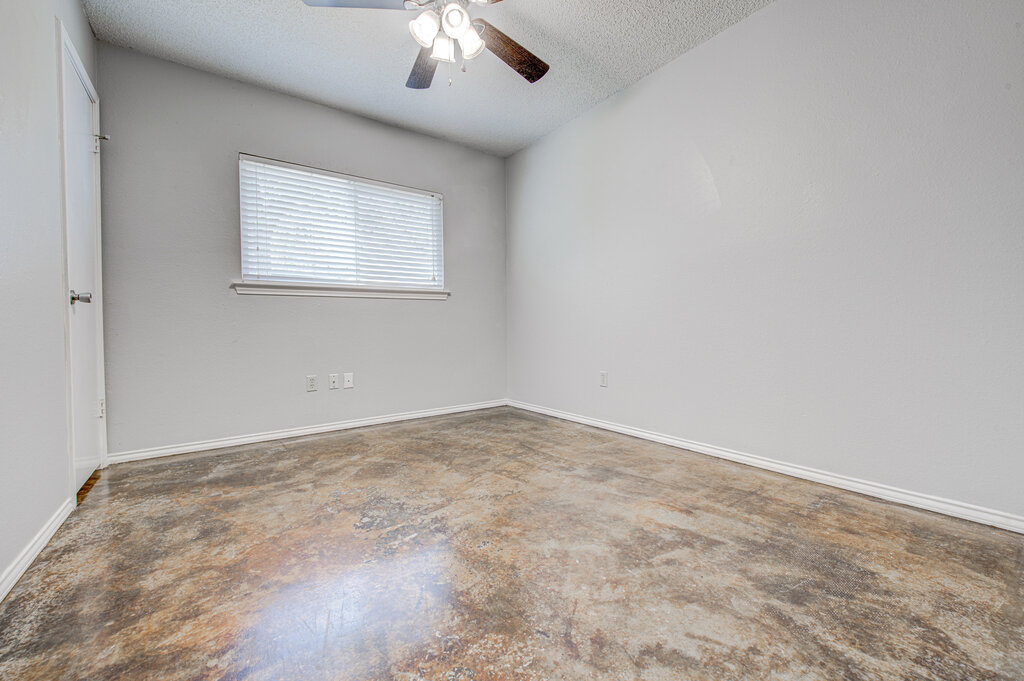 12925 Covington Trail Austin, TX 78727 - Photo 13 of 28 Spare room with a textured ceiling, unfinished concrete flooring, and ceiling fan