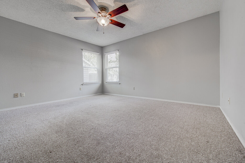 12925 Covington Trail Austin, TX 78727 - Photo 15 of 28 Empty room featuring carpet flooring, a textured ceiling, and a ceiling fan