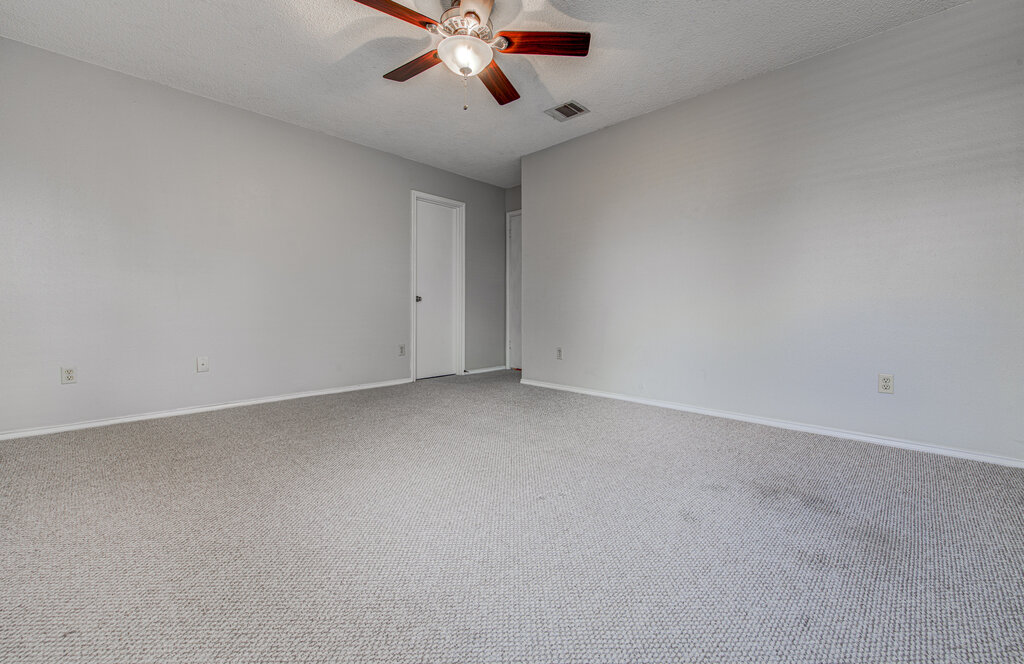 12925 Covington Trail Austin, TX 78727 - Photo 16 of 28 Empty room featuring a textured ceiling, carpet flooring, and a ceiling fan