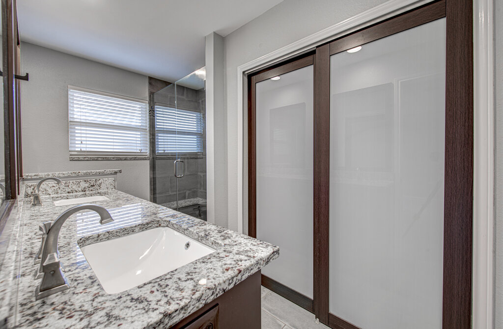 12925 Covington Trail Austin, TX 78727 - Photo 17 of 28 Full bathroom featuring double vanity and a shower stall
