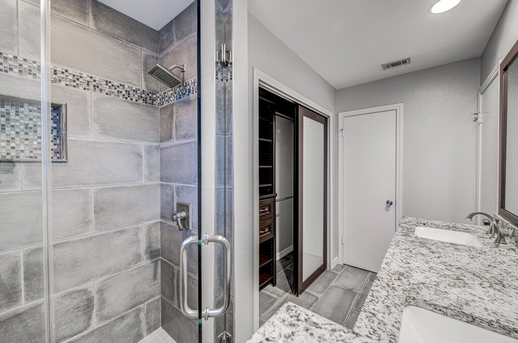 12925 Covington Trail Austin, TX 78727 - Photo 19 of 28 Bathroom featuring a shower stall, double vanity, and recessed lighting