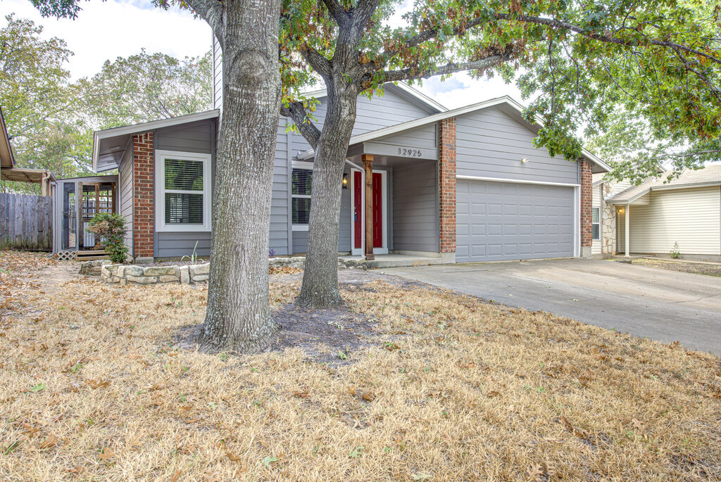 12925 Covington Trail Austin, TX 78727 - Photo 2 of 28 View of front of property featuring concrete driveway, an attached garage, and brick siding
