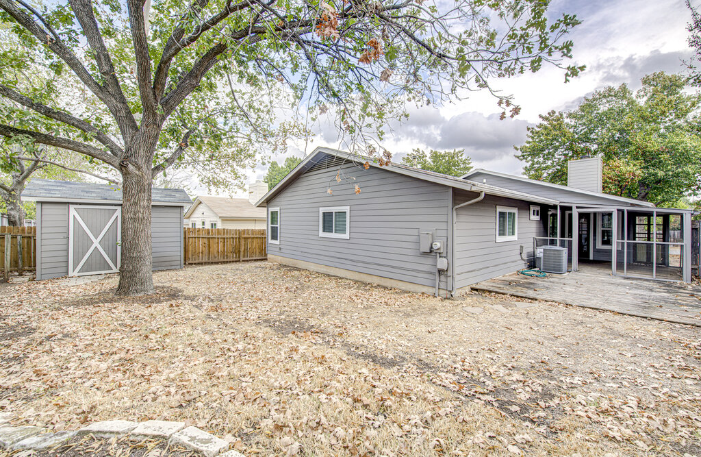 12925 Covington Trail Austin, TX 78727 - Photo 25 of 28 Rear view of property featuring a chimney, a storage shed, and a wooden deck