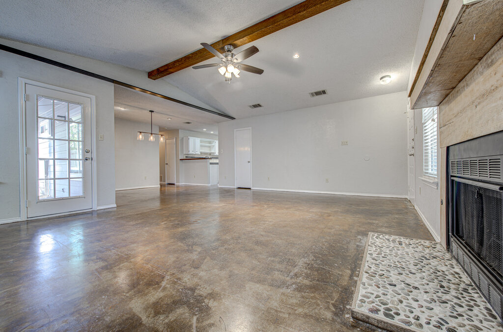 12925 Covington Trail Austin, TX 78727 - Photo 5 of 28 Unfurnished living room featuring ceiling fan, concrete floors, a textured ceiling, and a chandelier