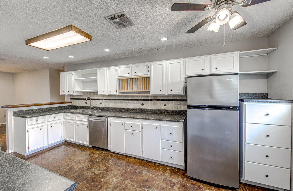 12925 Covington Trail Austin, TX 78727 - Photo 9 of 28 Kitchen with open shelves, dark countertops, appliances with stainless steel finishes, white cabinets, and tasteful backsplash