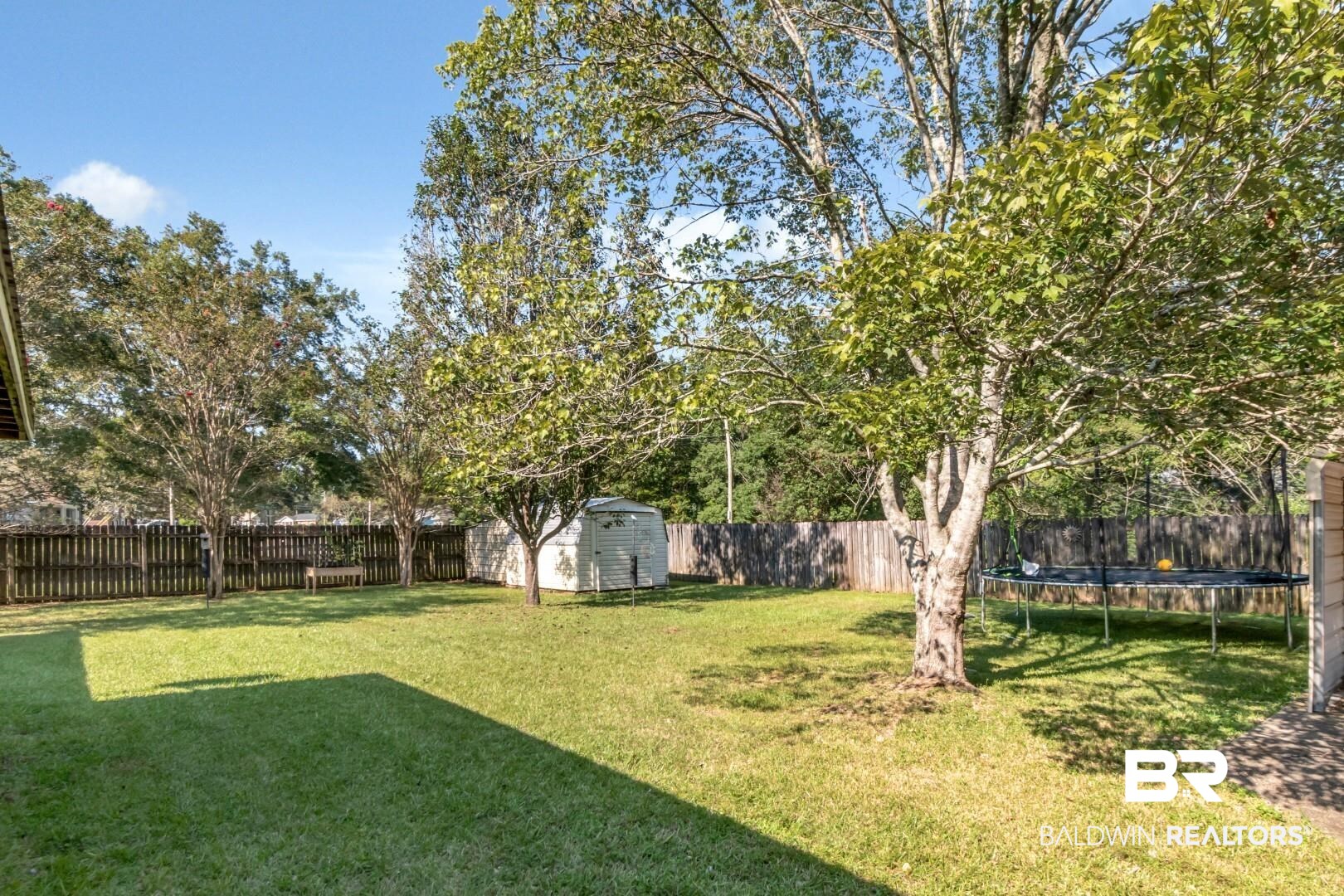 1345 Camden Court Mobile, AL 36695 - Photo 22 of 31 Fenced backyard with a storage unit and a trampoline