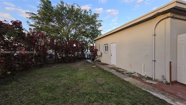 a backyard of a house with table and chairs