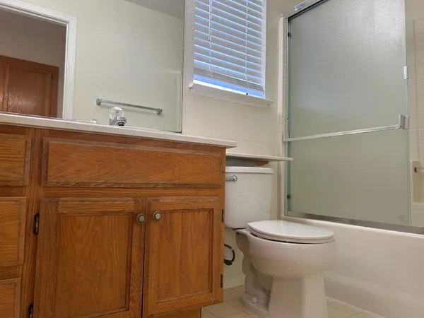 a bathroom with a granite countertop toilet and a sink