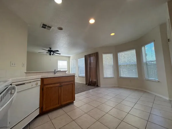 a large kitchen with a large counter top space appliances and cabinets