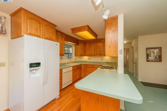 a kitchen with stainless steel appliances granite countertop a refrigerator a stove and a sink