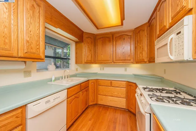 a kitchen with stainless steel appliances granite countertop a sink a stove and cabinets