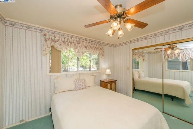 a bedroom with a large bed and a chandelier