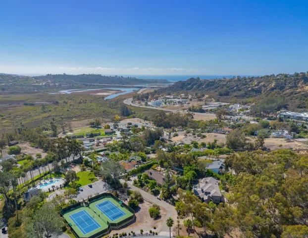 a view of a yard with plants and a wooden bench