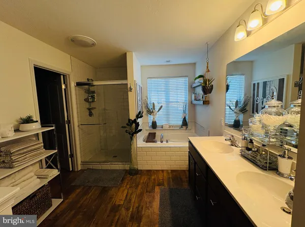 a bathroom with a double vanity sink a mirror and shower