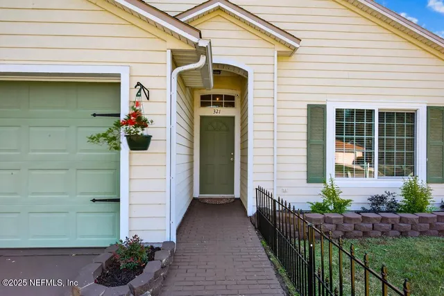 a front view of a house with a potted plant