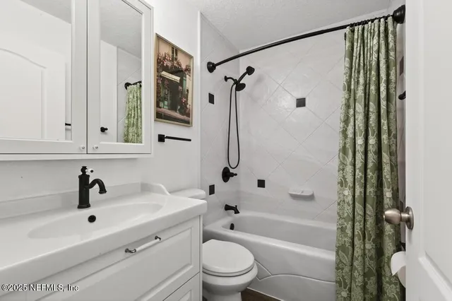 a bedroom with a bed and a flat tv screen on the dresser