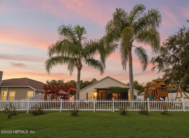 a view of a house with a yard and potted plants