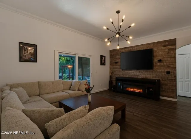 a living room with furniture a flat screen tv and a fireplace