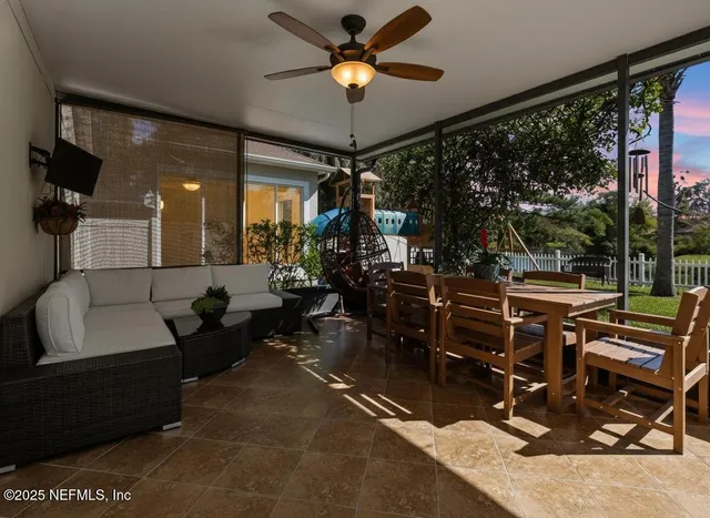 a living room with patio furniture and a chandelier